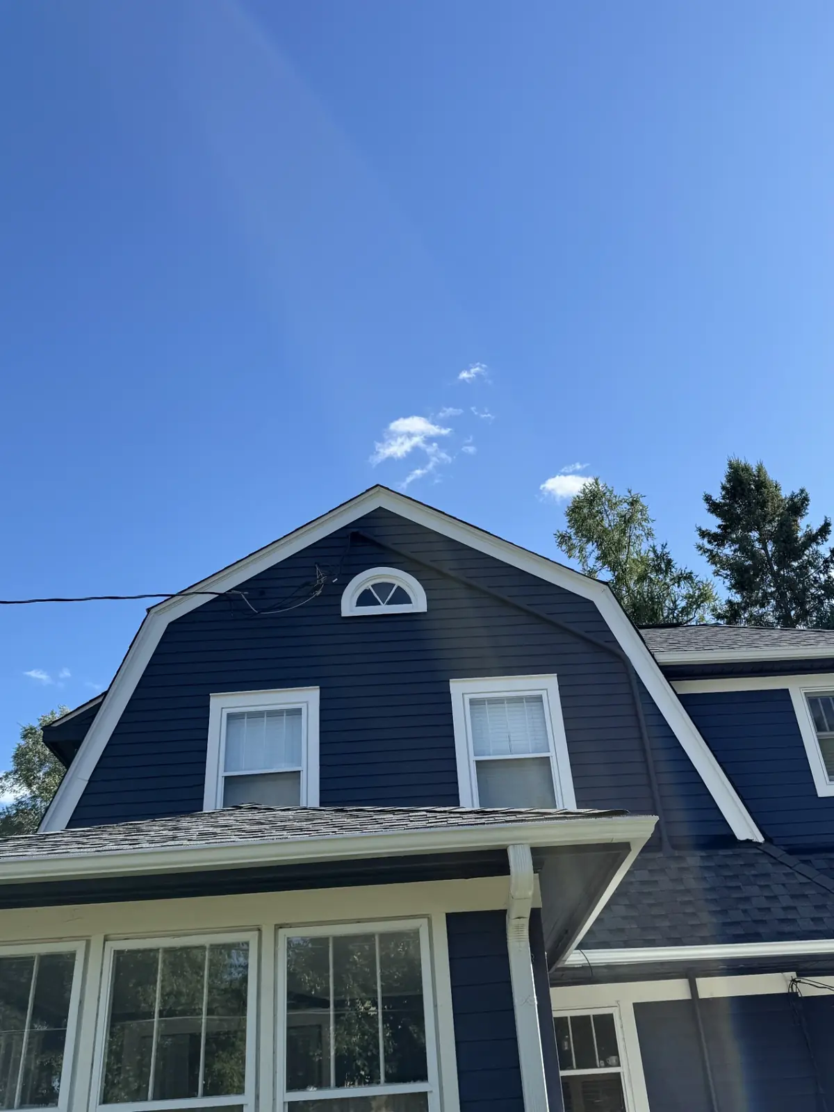 Same navy home after a full exterior repaint with crisp white trim