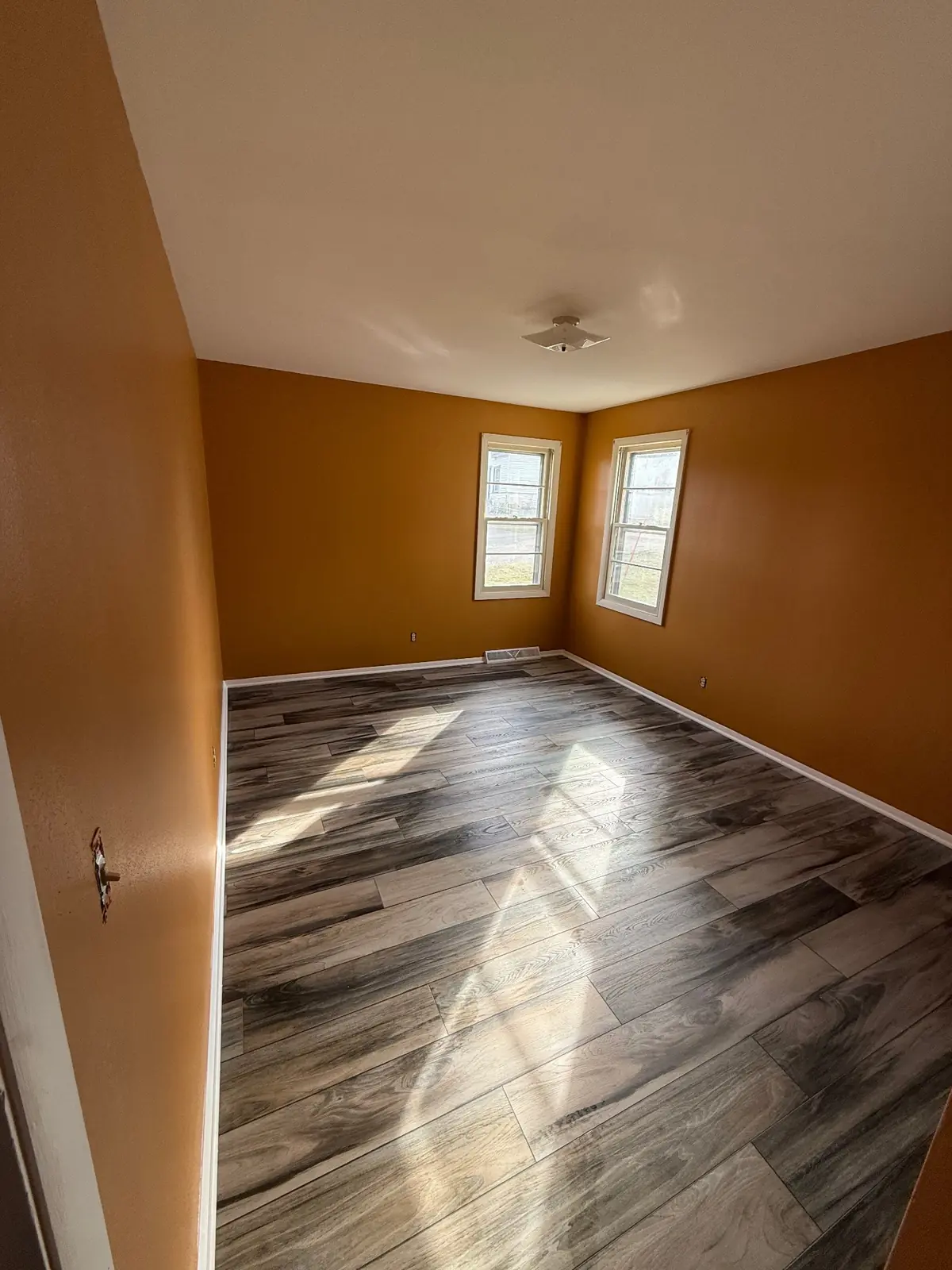 Bedroom painted in a warm golden tone with a bright white ceiling
