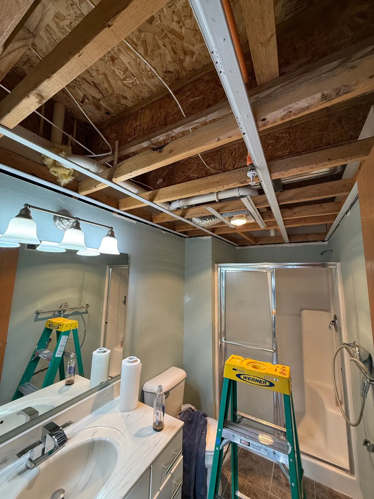 Bathroom with ceiling removed down to the joists during repairs