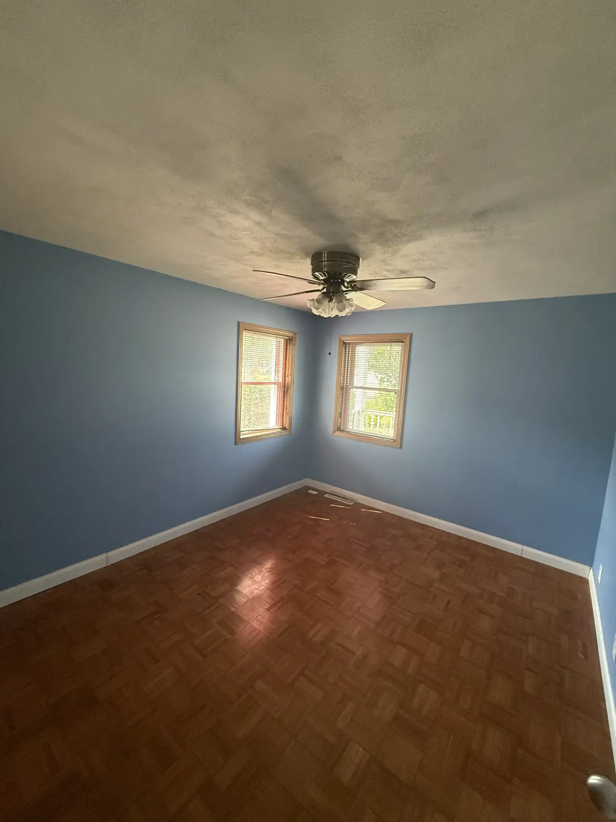 Bedroom with soft blue walls and white trim