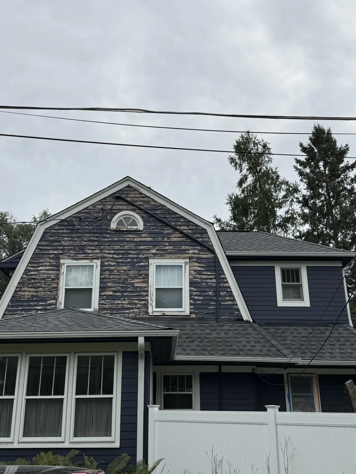 Navy home with heavily peeling siding before repainting