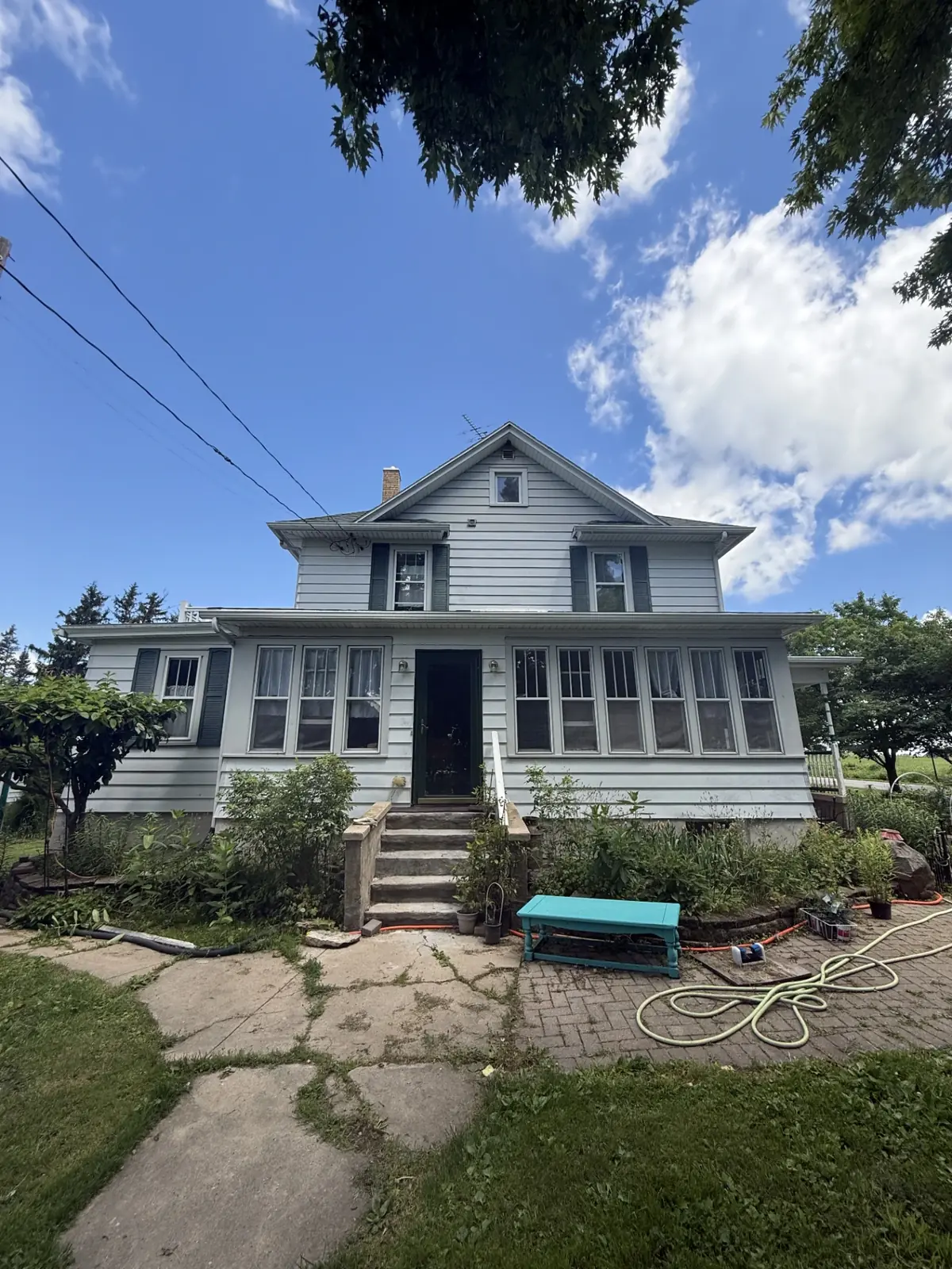 Faded pale farmhouse front before exterior painting
