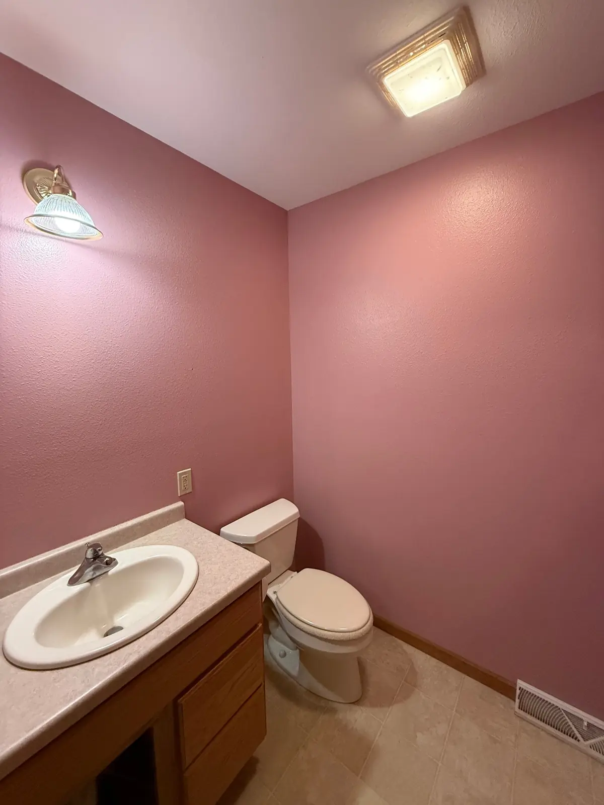 Bathroom painted a soft dusty rose with white trim